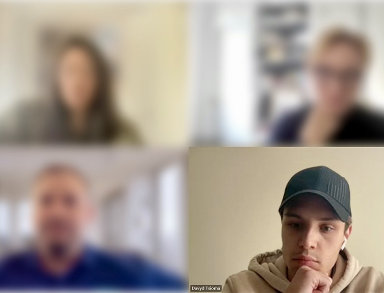 Davyd listening on a video call, the other participants blurred